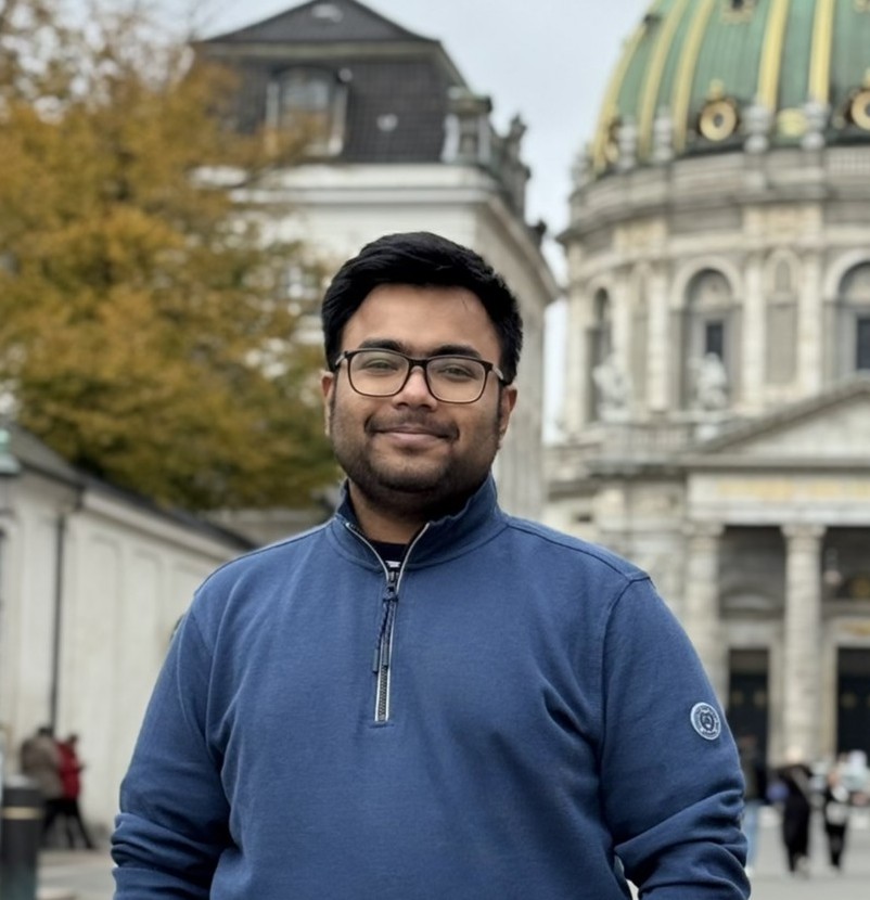KM Aminul Islam head-and-shoulders portrait looking at the camera with a slight smile wearing a dark shirt with a blurred indoor background conveying a professional and approachable tone